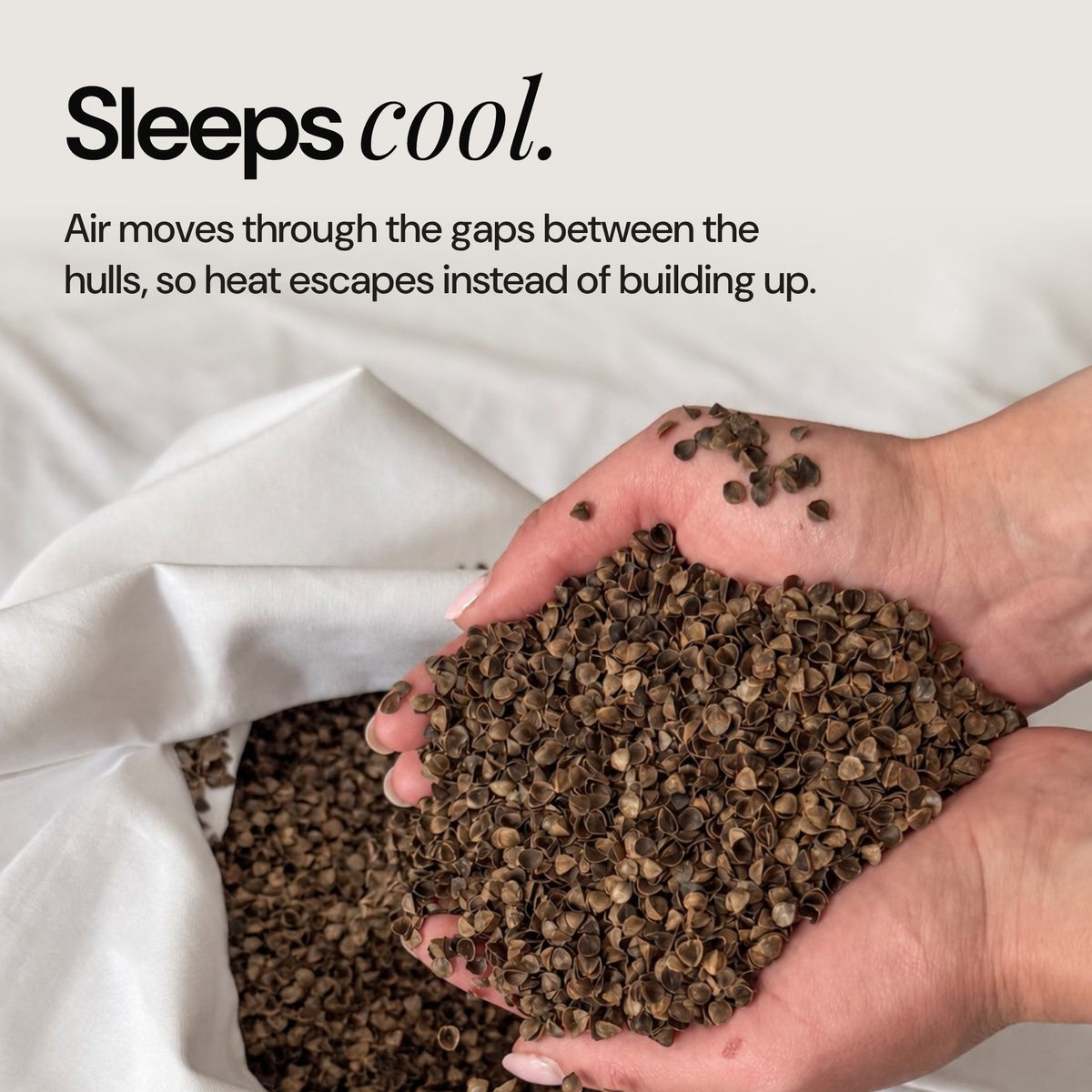 Hands holding buckwheat hulls: air flows between the hulls so the pillow sleeps cool