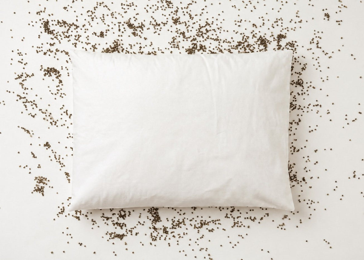 Buckwheat pillow seen from above, surrounded by scattered buckwheat hulls
